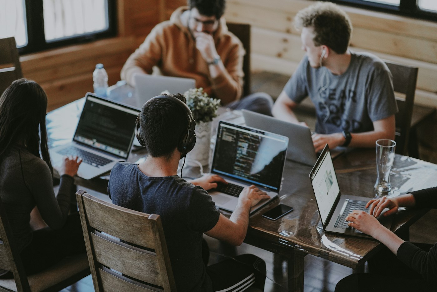 Colleagues smiling while collaborating around a laptop
